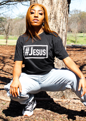 Man wearing a #Jesus Survival tee looking down and pulling down on his shirt